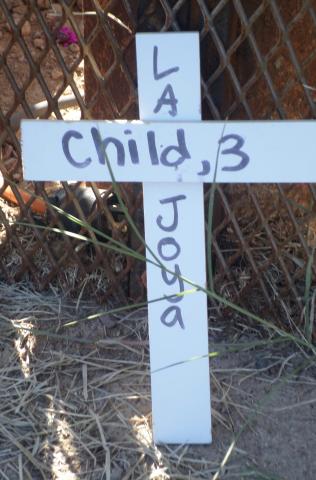 A cross commemorates a three-year-old child at the Eloy Detention Center vigil (Photo by Katharine Davies Samway)