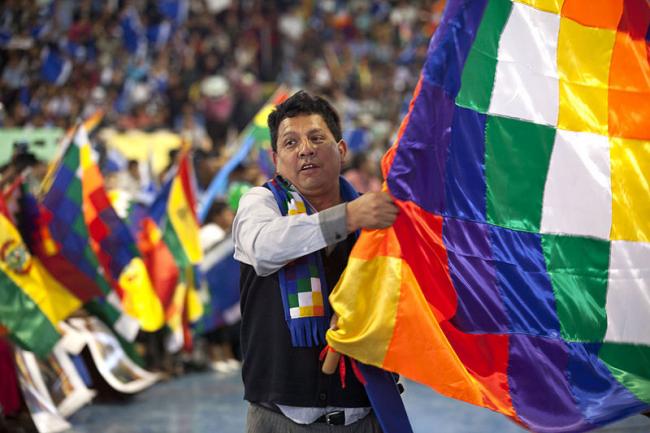 A person waves the Wiphala during a gathering of social movements in Cochabamba, Bolivia, July 2013. (Photo by Ricardo Patiño/Wikimedia)