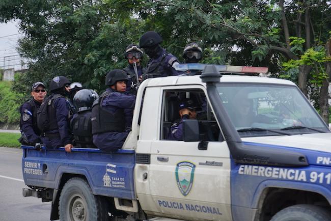 A National Police vehicle loaded with officers drives on the highway to Puerto Cortés in 2018. (Amelia Frank-Vitale)