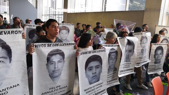 Family members hold posters with the faces of the forcibly disappeared students from Ayotzinapa teachers' college (Wotancito, Wikimedia Commons / CC BY-SA 4.0) 