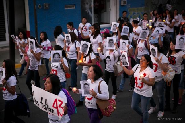 During the Global Action for Ayotzinapa on May 11, 2014, in Oaxaca, people marched wearing commemorative shirts and held up signs with images of the 43 disappeared students. (Montecruz Foto/Creative Commons: Attribution Share Alike)