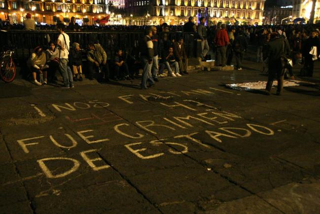 People gather in Mexico City on May 11, 2014, for a march commemorating the 43 who disappeared at Ayotzinapa. On the ground the slogan 