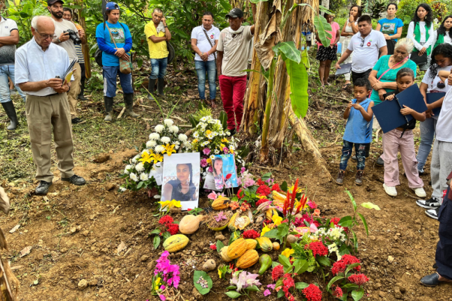 Unos miembros de la Comunidad de Paz se reúnen junto con aliados y acompañantes alrededor de un memorial con fotos de Nalleli Sepúlveda en La Holandita, el asentamiento principal de la comunidad, el 23 de marzo 2024. (Moira Birss)