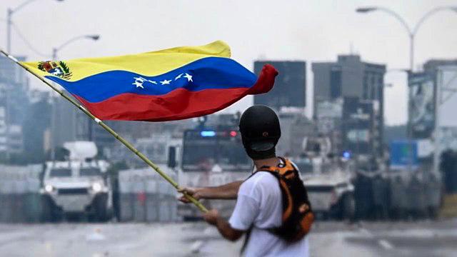 A young protestor faces the Venezuelan National Guard in May 2017. (Wikimedia Commons)