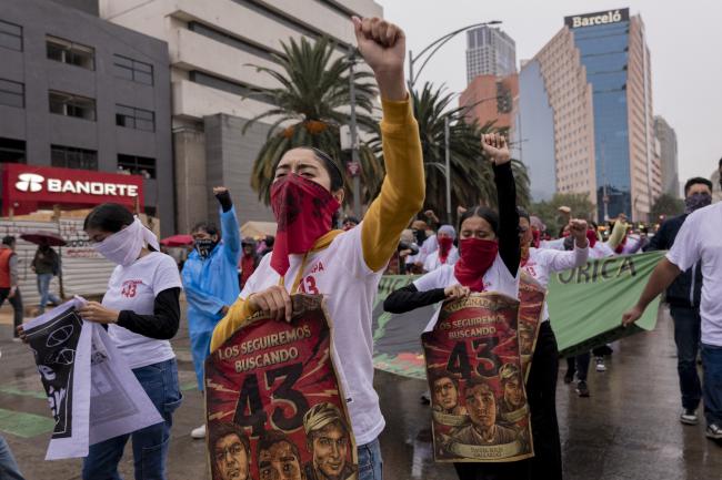 Protesters march through the streets of Mexico City on September 26, 2024, demanding answers for the students who were disappeared 10 years ago. They hold posters that read 