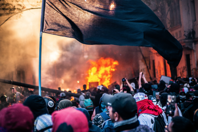 Protesters wave a black flag during a demonstration in Santiago, November 12, 2019. (Matias Fernandez / CC BY-SA 4.0)