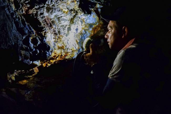 An artisanal miner inspects a gold vein in tunnels deep within Briceño's hillsides. (Photo by Alex Diamond)