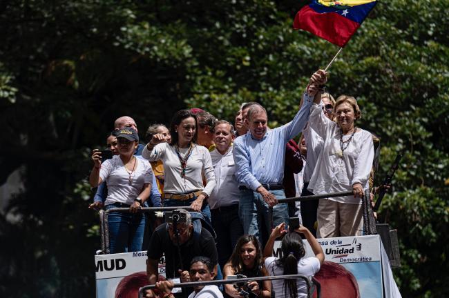 El candidato presidencial Edmundo González Urrutia y líder opositora María Corina Machado saludan a miles de simpatizantes durante un mitin después de las elecciones en Altamira, al este de Caracas, el 30 de julio de 2024. (Marcelo Pérez del Carpio)