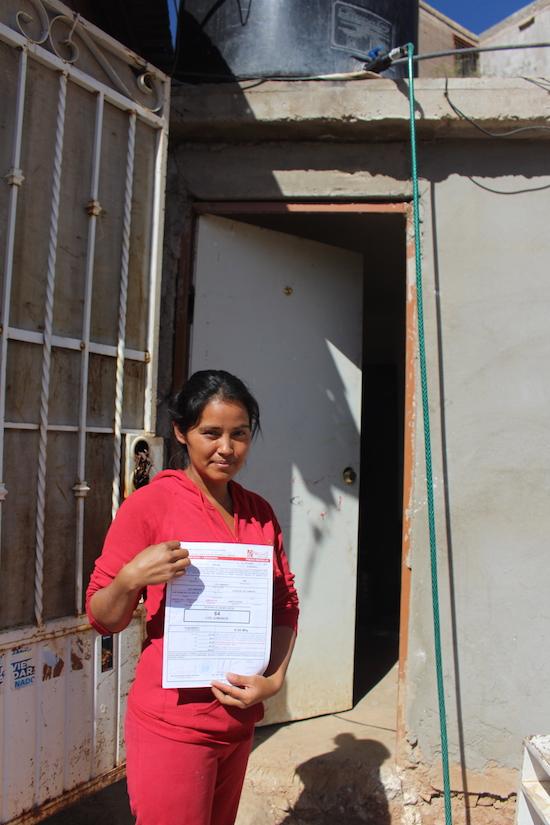 Cristina Navarro displays a certificate of occupancy for her home in Colosio, a step in the way to getting legal recognition. (Noah Silber Coats)