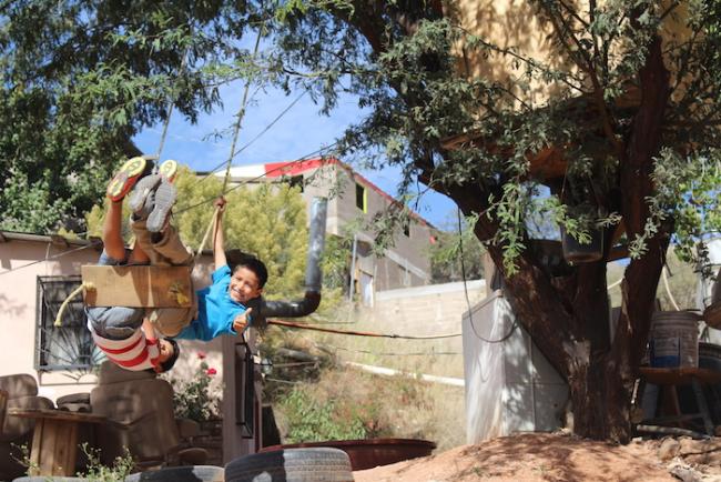 Kids play on a swing in the Colosio neighborhood. (Noah Silber Coats)