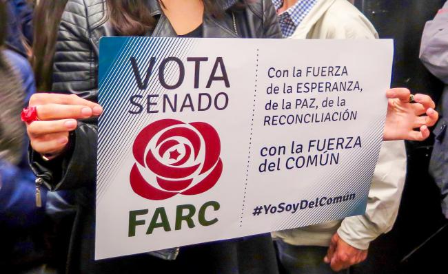 A woman holds a FARC Senate poster at the launch of the party's new headquarters in Bogotá. (Photo by Emma Shaw Crane)