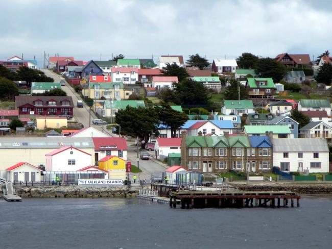 A photograph of Stanley. A sign near the jetty reads 